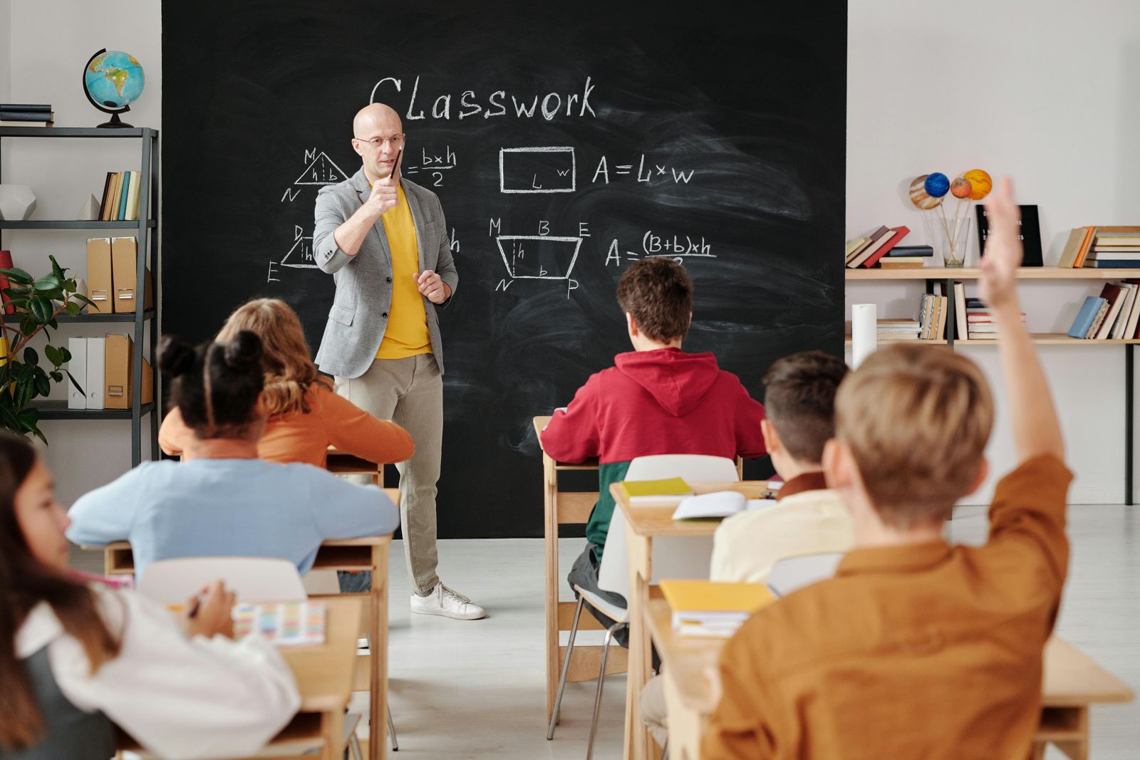 Des collégiens en classe, professeur au tableau